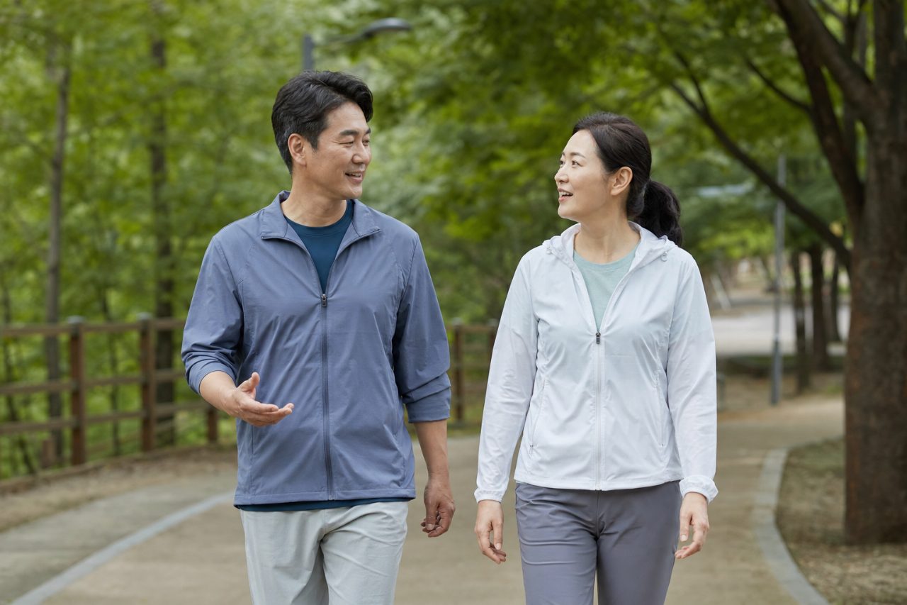 공원 산책을 하며 대화하는 중년 부부의 뒷모습