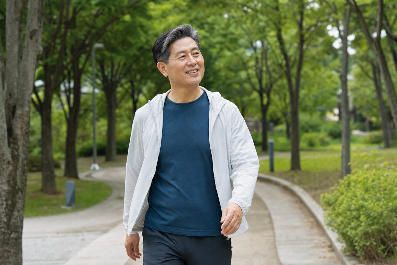 공원에서 느긋이 산책하며 스트레스를 푸는 40대 남성
